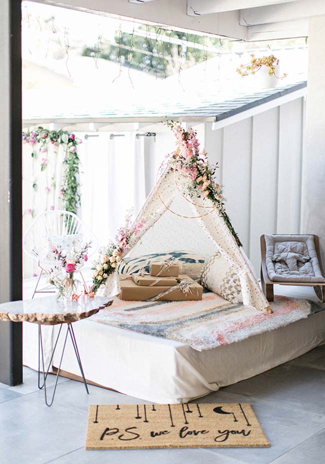 Cantinho especial para a futura mamãe: sofá com almofadas, flores e presentes para o bebê