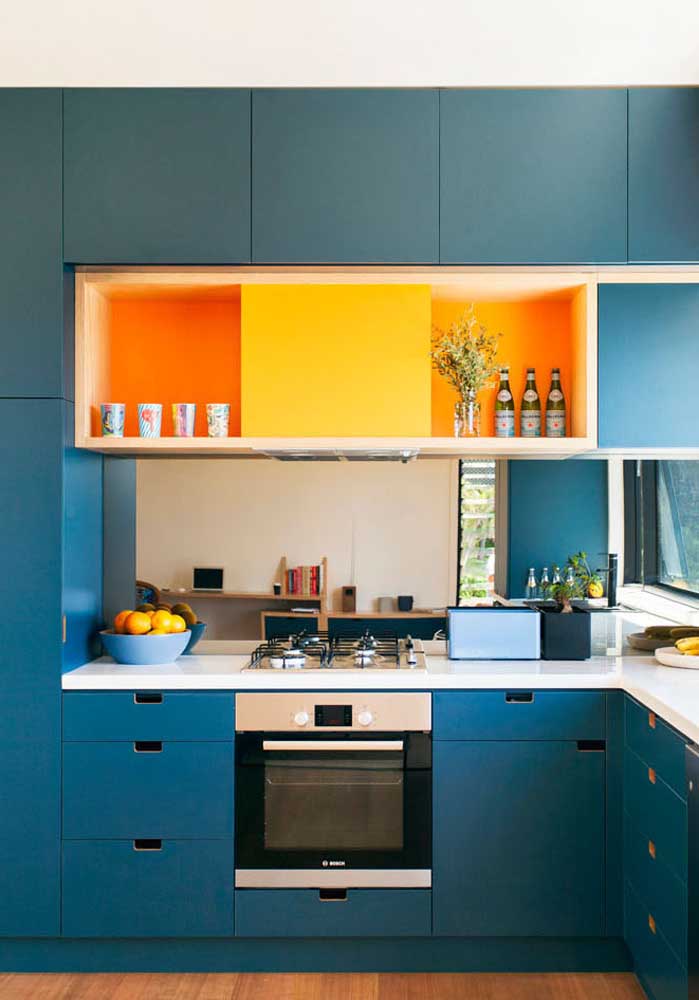 E num tom mais escuro, o azul turquesa combinado com o laranja e o amarelo trazem mais vida para dentro desta cozinha