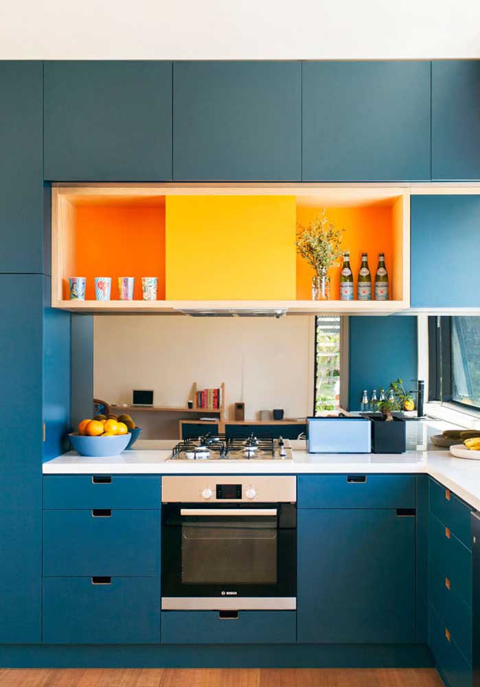 E num tom mais escuro, o azul turquesa combinado com o laranja e o amarelo trazem mais vida para dentro desta cozinha
