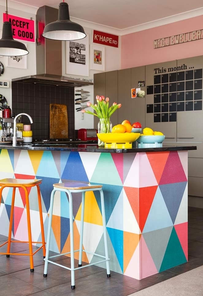 Uma cozinha cheia de referências e cores: destaque aqui para a bancada em alvenaria, pintada com um padrão triangular com tinta colorida – um projeto criativo e fácil para fazer em casa!