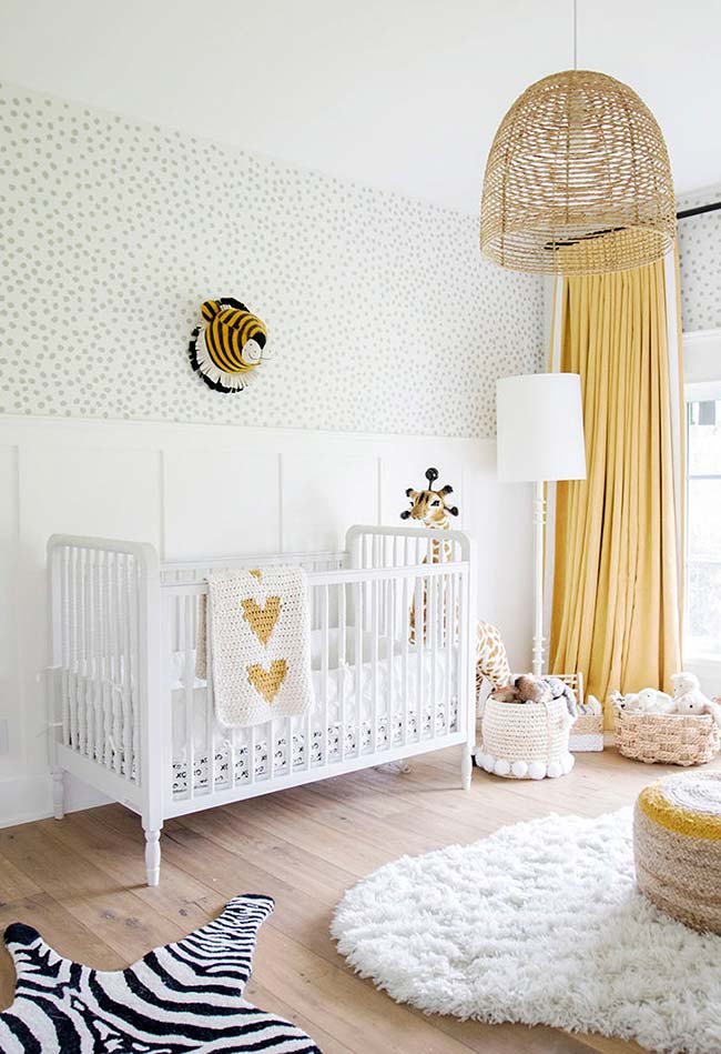 Branco e amarelo neste quarto de bebê super confortável e cheio de bichinhos