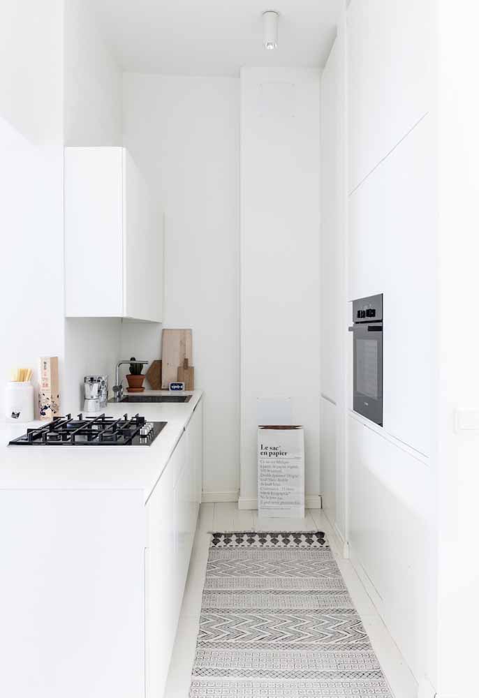 Cozinha branca com pouco do estilo minimalista em modelo de corredor