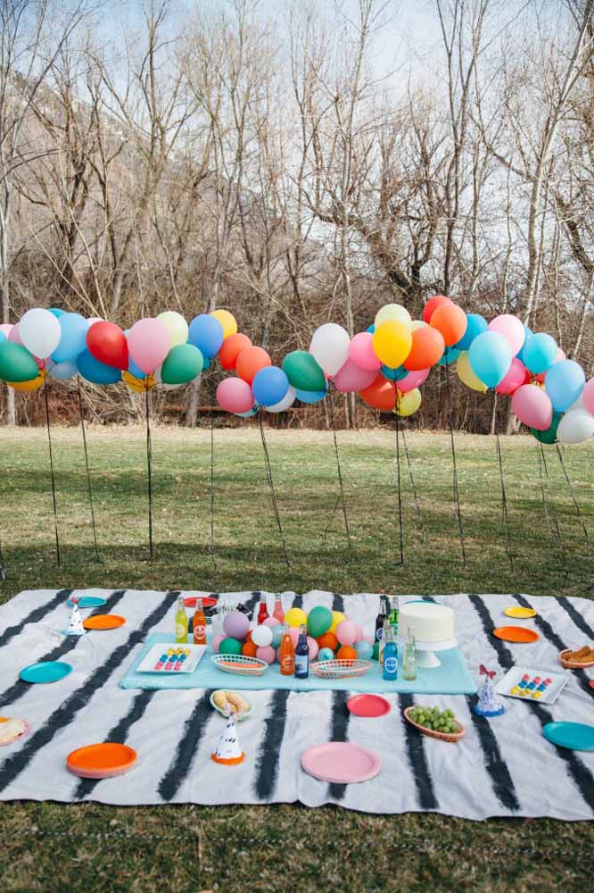 Reserve um cantinho no parque, coloque uma toalha, decore com itens coloridos e chama a criançada para fazer um piquenique diferenciado