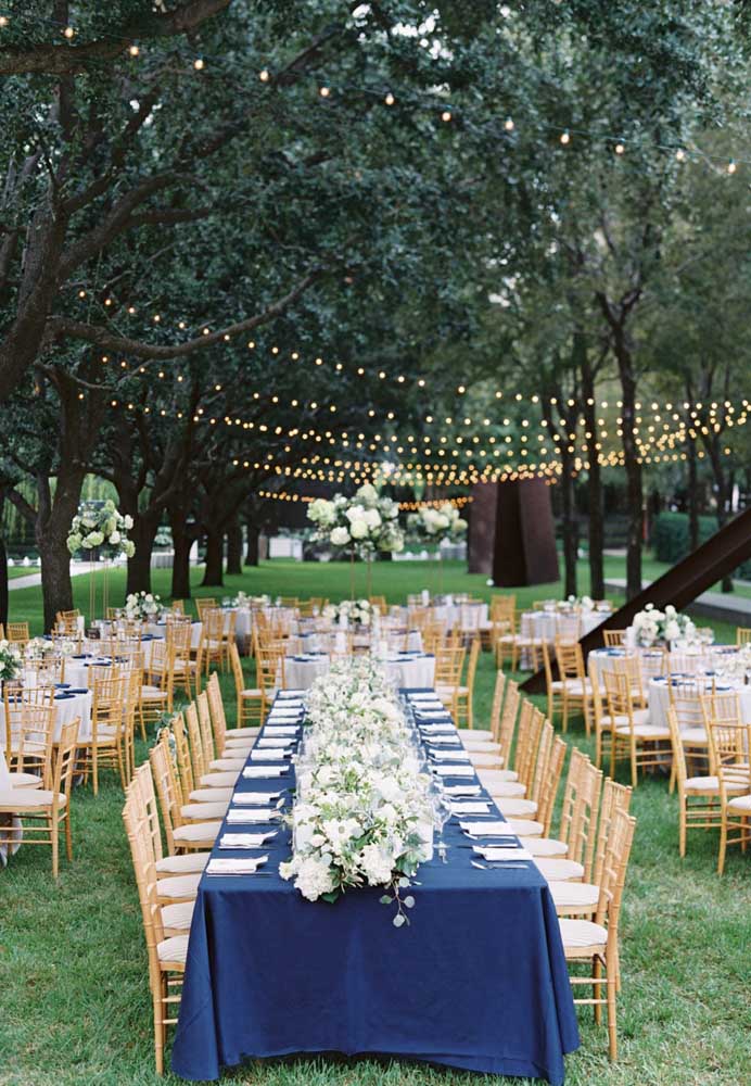 A mesa principal dessa festa foi decorada com uma enorme e elegante toalha azul royal; para as mesas menores, toalhas brancas com detalhes em azul