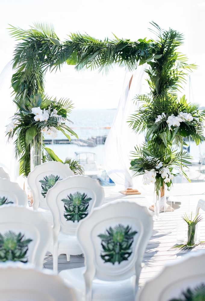 Os arcos feitos com folhas e flores é o que mais se usa na decoração de casamento na praia porque o efeito é realmente encantador.