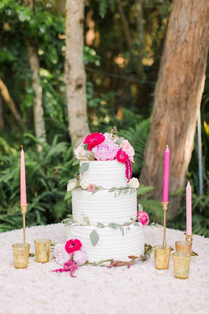 Em uma festa ao ar livre e de dia, você pode optar por um bolo mais simples com andares e decorar a mesa apenas com velas colocadas em castiçais.