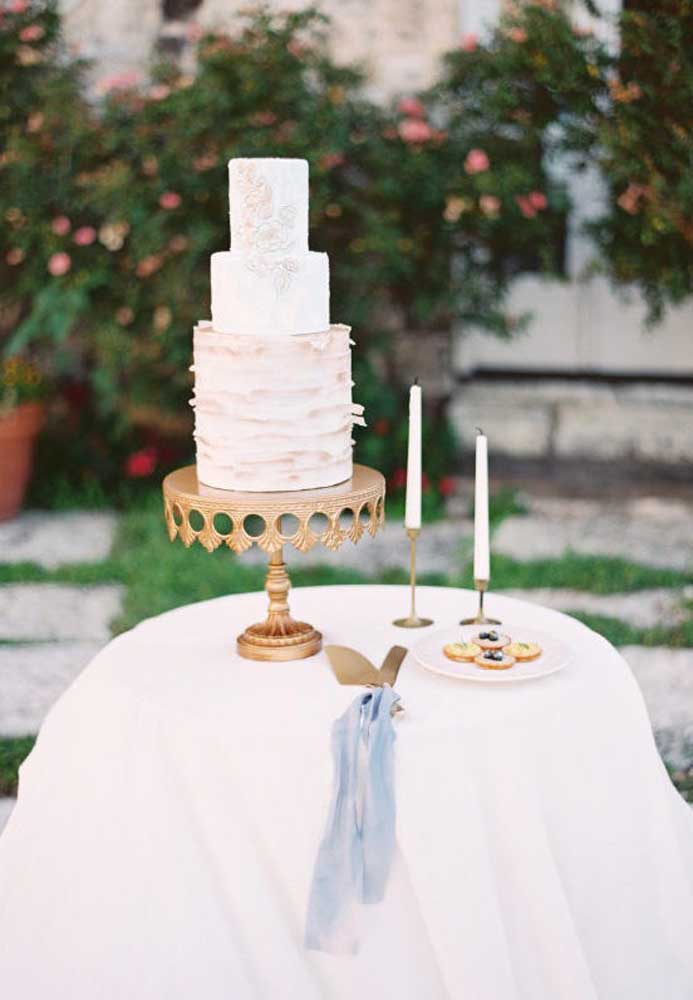 Escolha uma base requintada para colocar o bolo de casamento. A decoração da mesa pode ser mais simples, mas a vela não pode faltar.