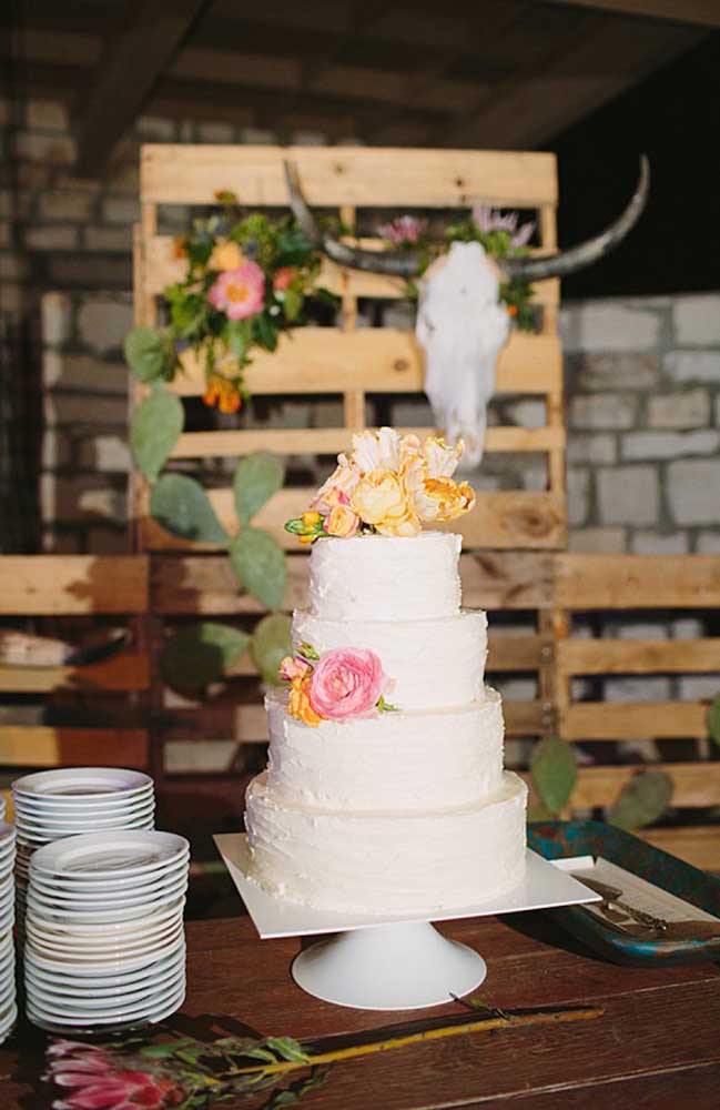 Se a decoração do casamento é algo mais rústico, você pode fazer um bolo tradicional e colocá-lo em uma mesa de madeira. Decore apenas com alguns arranjos de flores.