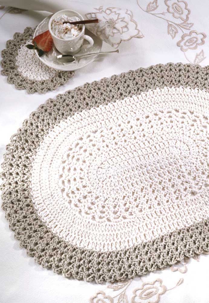 Tapete de crochê oval branco com bordas cinza; repare na delicadeza do porta xícaras no mesmo estilo do tapete