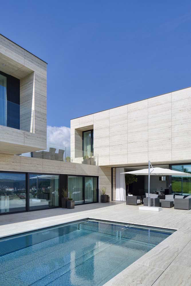 Casa grande moderna com piscina; o que chama atenção nesse projeto é o formato em L da construção
