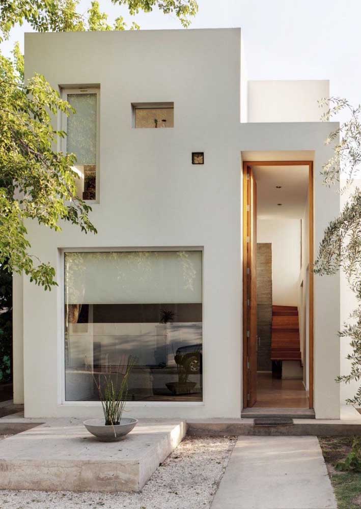 Fachada de casa simples moderna; destaque para as janelas de vidro que garantem uma entrada maior de luz natural