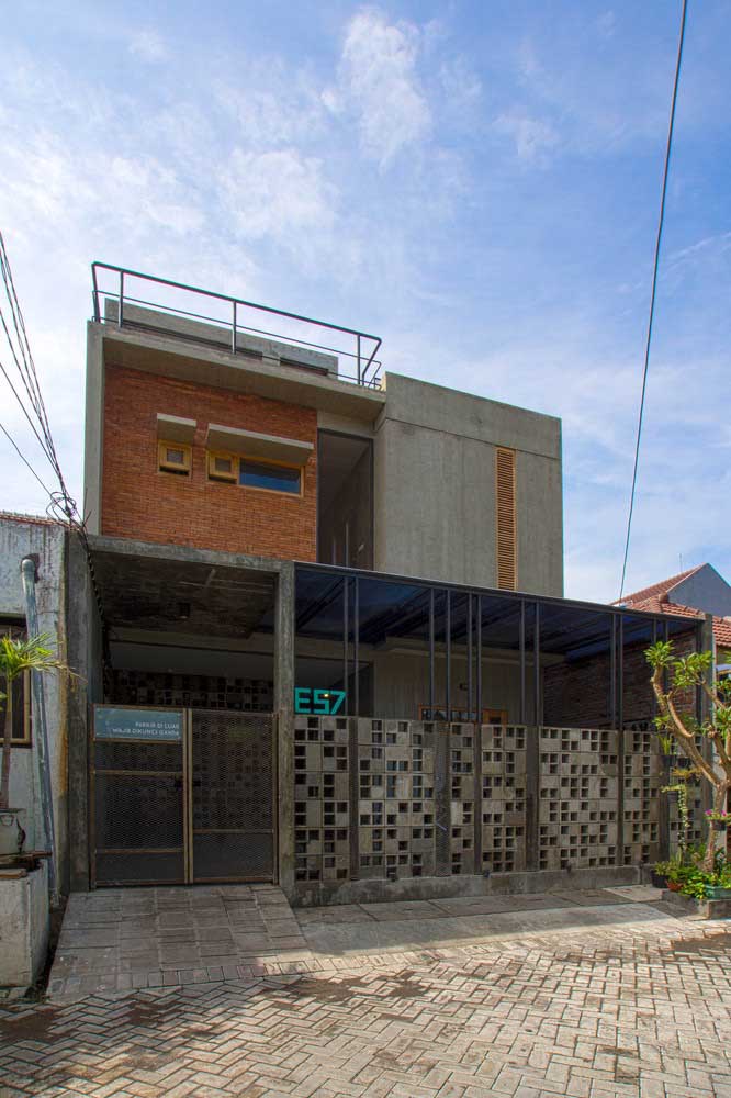 Fachada de casa simples com dois pavimentos e garagem; a combinação entre tijolinho a vista e concreto aparente trouxe modernidade para fachada