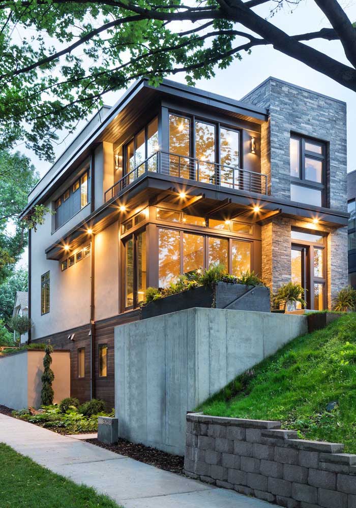 Casa moderna com três andares cercada pela natureza; o ambiente em volta também é responsável pela beleza da casa