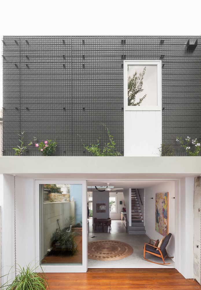 Fachada de casa moderna com revestimento na parte superior que se assemelha a treliças metálicas
