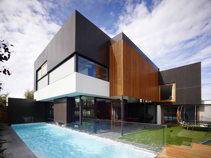 Fachada de casa moderna com piscina e o uso das cores preferidas para esse tipo de projeto: o preto e o branco 