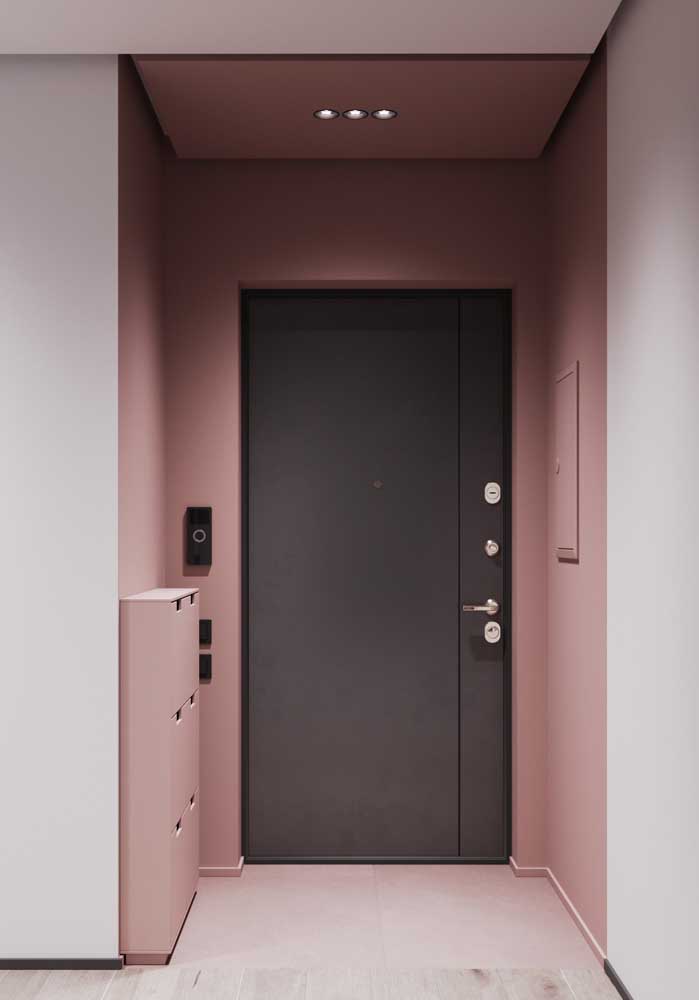 O hall de entrada cor de rosa ficou mais moderno e despojado com a porta de madeira preta