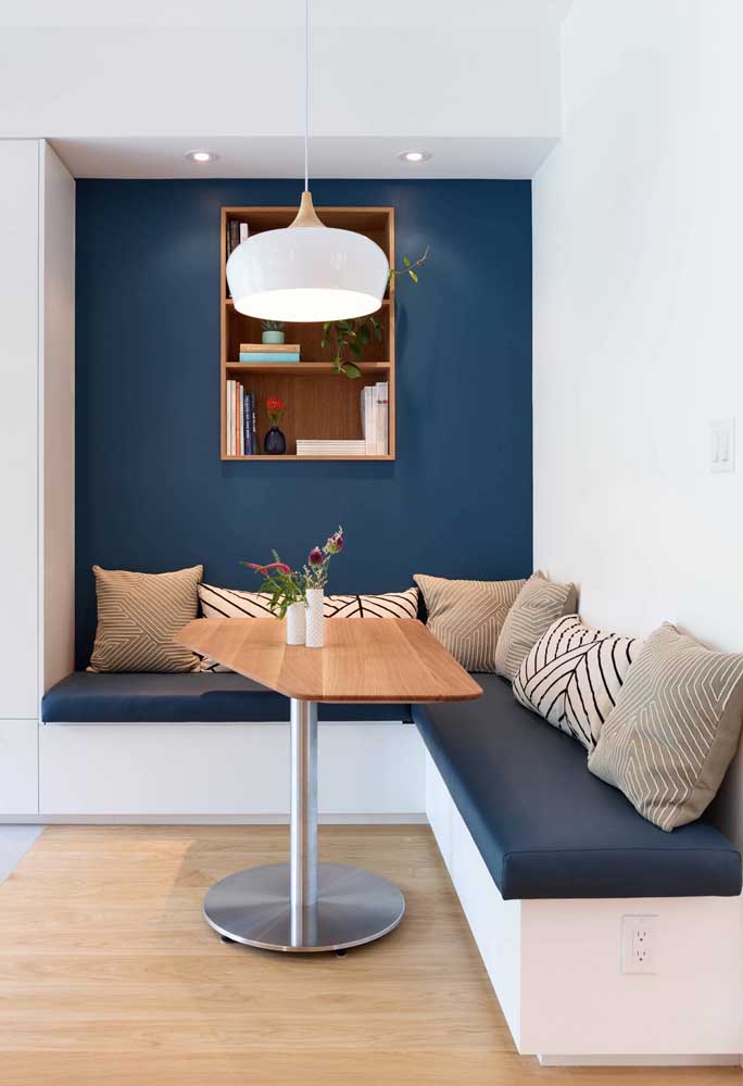 Sala de jantar com canto alemão em tons de branco e azul marinho; repare no equilíbrio formado na composição com as duas cores