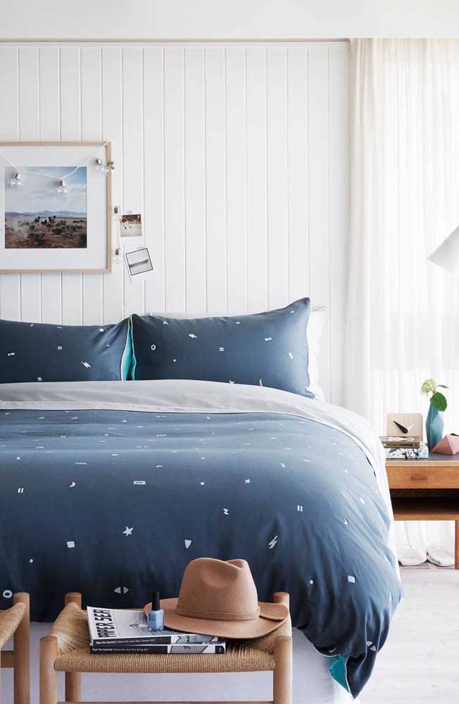 Uma maneira simples e prática de inserir o azul marinho na decoração é usando-o em roupas de cama, como nesse quarto