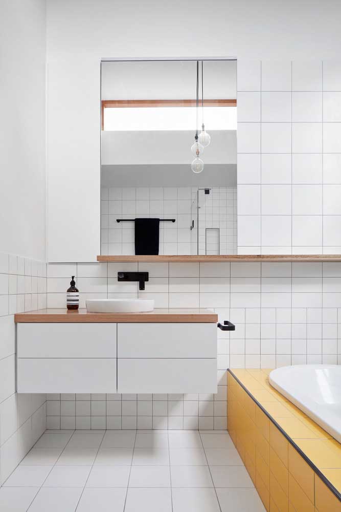 A escolha para este banheiro branco foram os azulejos quadriculados em tamanhos diferentes