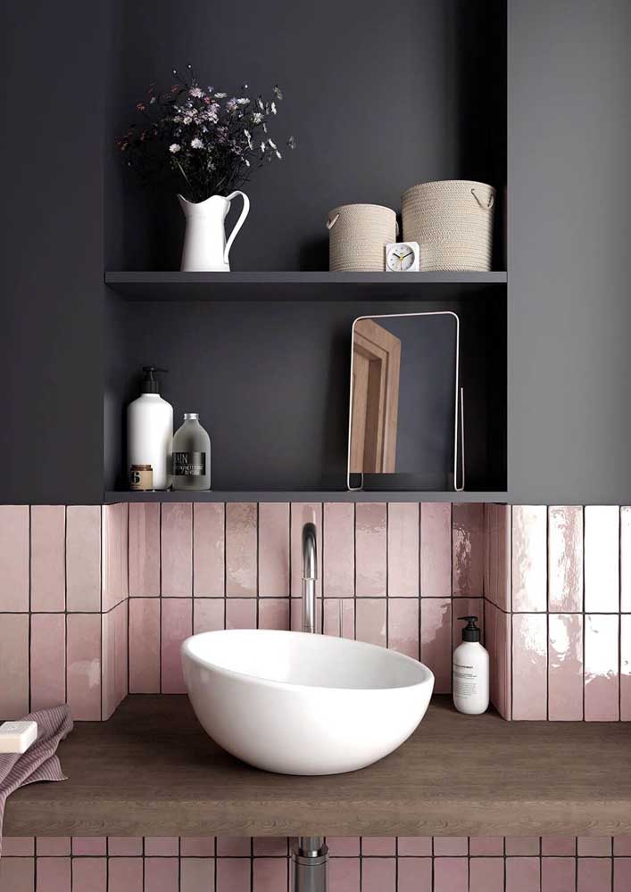 Esse banheiro contou com azulejos de metrô rosa formando um contraste incrível com a parede preta na metade superior da parede