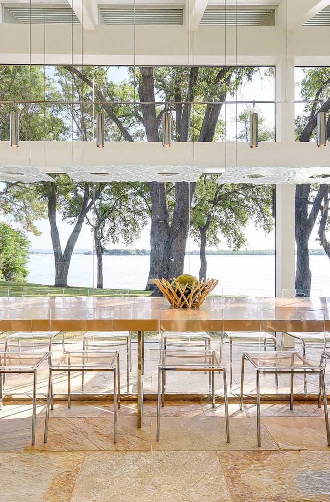Sala de jantar moderna com jogo de cadeiras de acrílico transparente; perceba quanta leveza e fluidez que as cadeiras de acrílico trazem para o ambiente