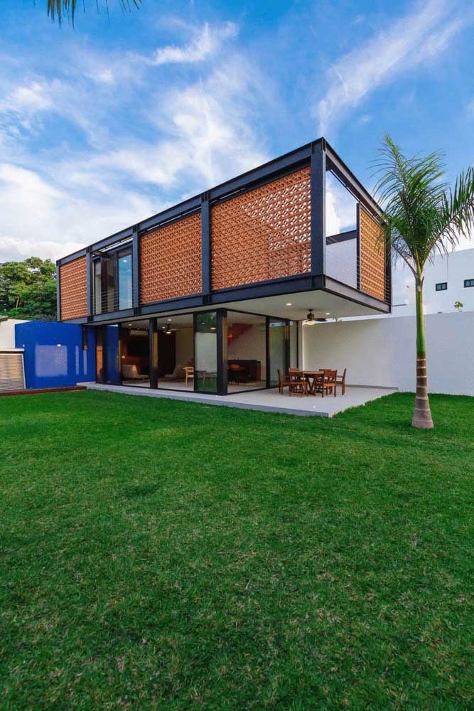 Casa em L simples, em terreno extenso, com cômodos abertos e varanda gourmet