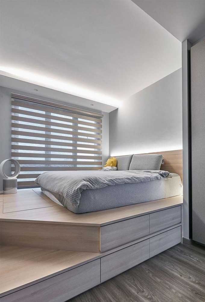 Quarto planejado com cama no chão sobre um pequeno mezanino; destaque para o suporte com gavetas construído abaixo do móvel