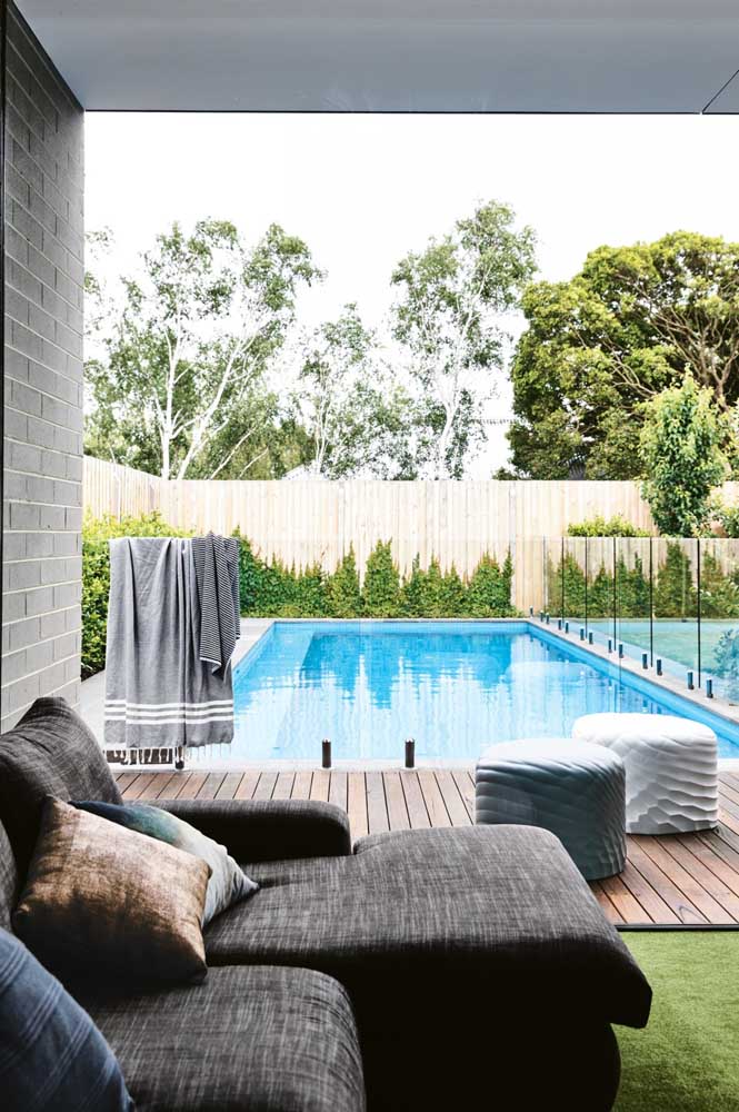 A área da piscina ficou perfeita com a escolha da cerca viva ao redor do ambiente