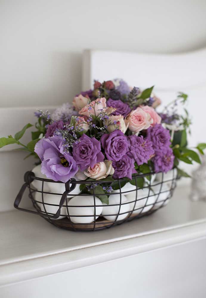 Olha que arranjo perfeito para a Páscoa. Folhas, flores e ovos dentro de um cesto de metal.