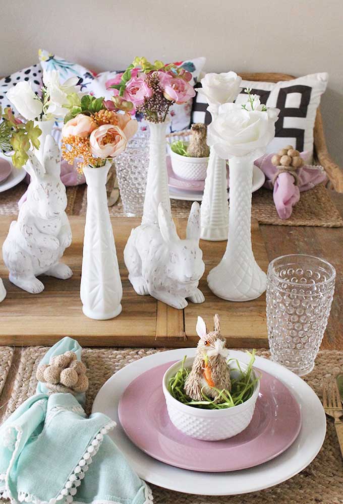 Decore a casa com coelhos de cerâmica e vasos de flores.