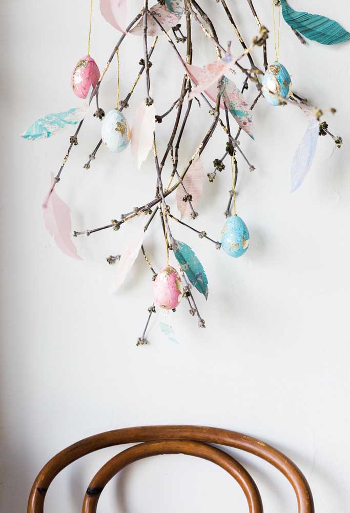 Reaproveite alguns galhos de árvores para fazer uma decoração com ovos personalizados.