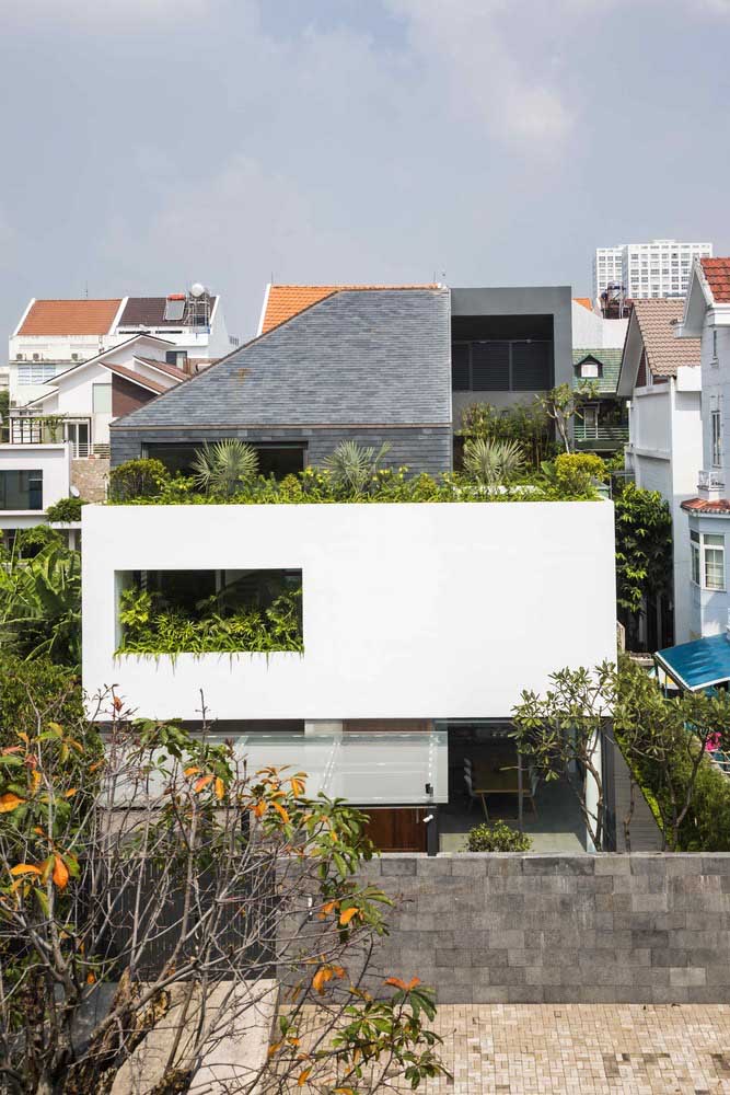 A frente dessa casa foi valorizada pelo uso das plantas; repare no contraste criado pelos tons de verde em meio as tonalidades neutras