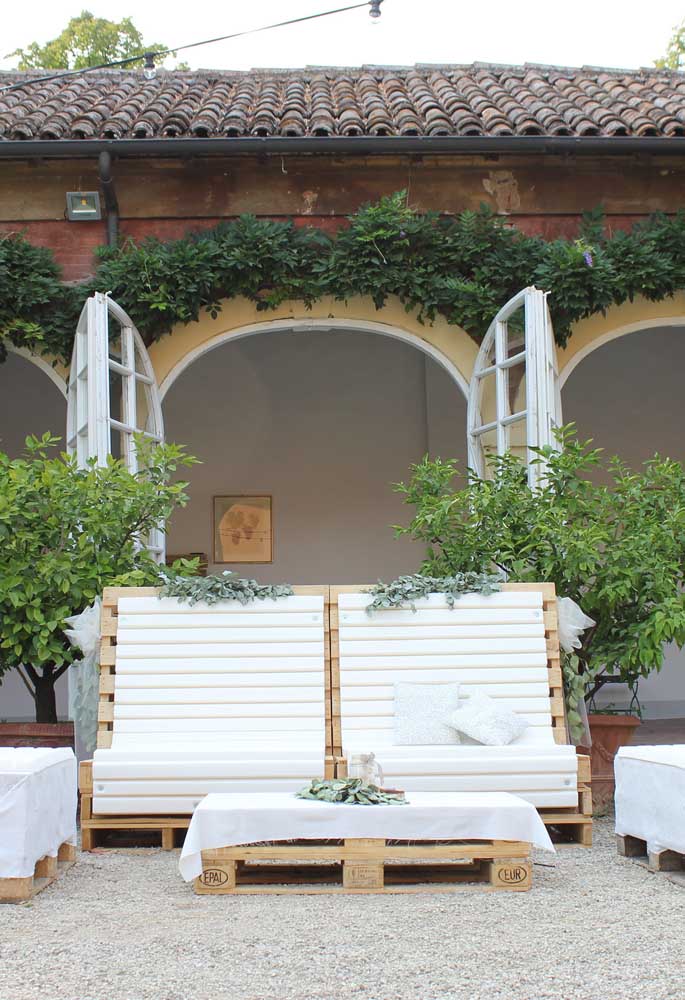 Conjunto de espreguiçadeiras e mesa de centro feito em pallets; a cobertura branca deu um charme a mais para a peça