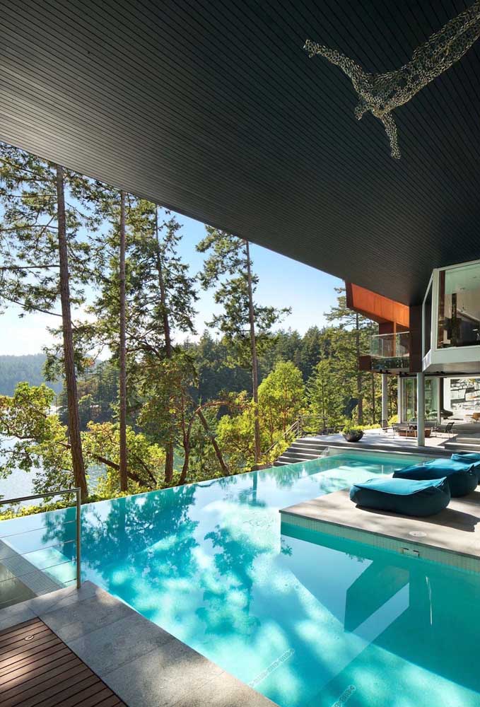Piscina com borda infinita para a casa contemporânea; parte da piscina recebeu cobertura
