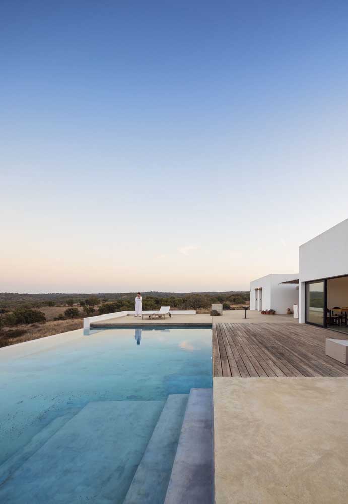 O terreno com declive ficou perfeito com a escolha da piscina com borda infinita