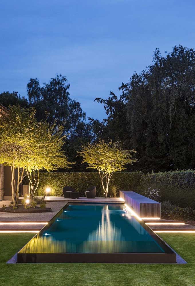 A piscina com borda infinita desta residência se tornou um perfeito lago em meio ao jardim
