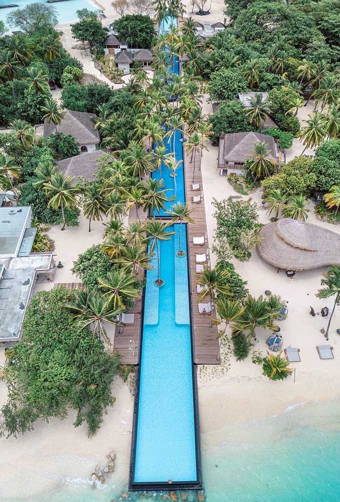 Vista de cima de um resort com piscina com borda infinita que termina no mar