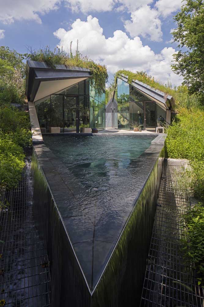 Esse modelo de piscina com borda infinita traz ao redor um vão com ralo para receber a água que escorre