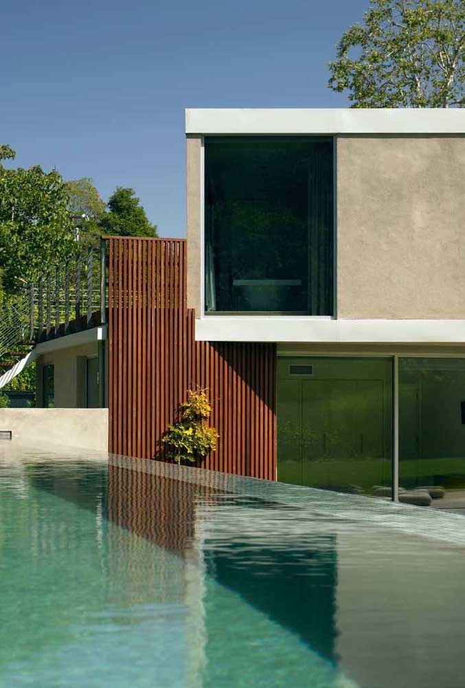 Essa piscina com borda infinita dá a impressão de que a água cai dentro da casa