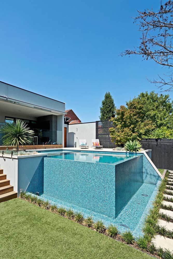 Aqui, a piscina com borda infinita foi construída em um terreno plano e precisou de bordas maiores para manter a impressão de profundidade