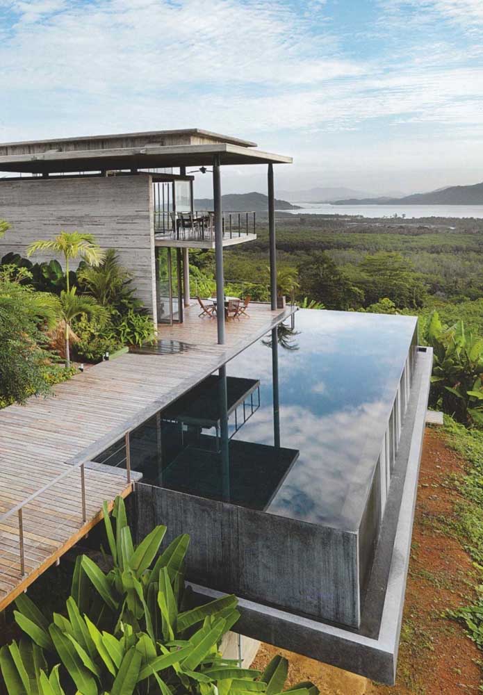 Piscina com borda infinita em casa de campo; perfeita para contemplar a natureza ao redor