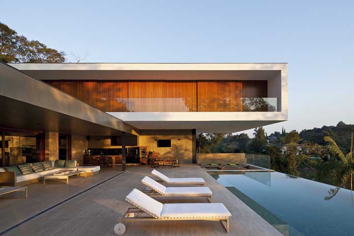 Casa moderna com piscina de borda infinita pronta para receber quem chega