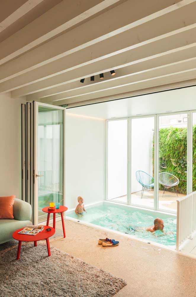 A diversão da família está garantida com essa piscina de fibra pequena dentro da sala de estar; um projeto original