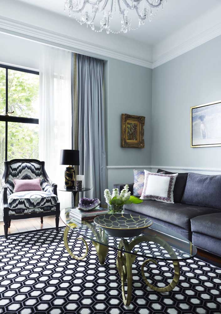 Sala de estar decorada em tom sobre tom de azul; para o sofá a cor escolhida foi o azul petróleo