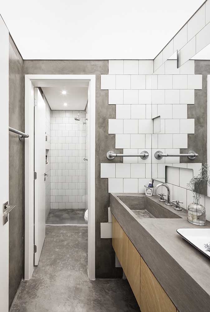 Quer deixar o banheiro mais moderno? Use revestimento no estilo cimento cru com alguns azulejos branco.