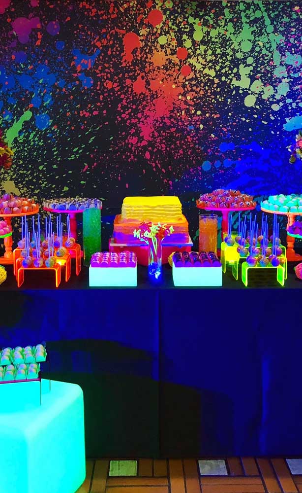 Essa festa neon traz como sugestão um painel borrado com tinta de diferentes tons 