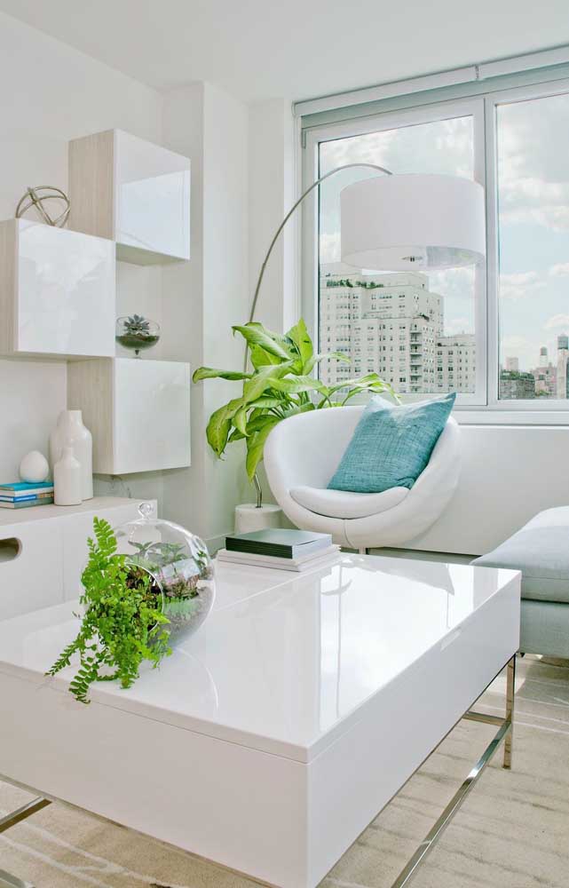 A sala branca, clean e moderna ganhou vida com o verde intenso das samambaias