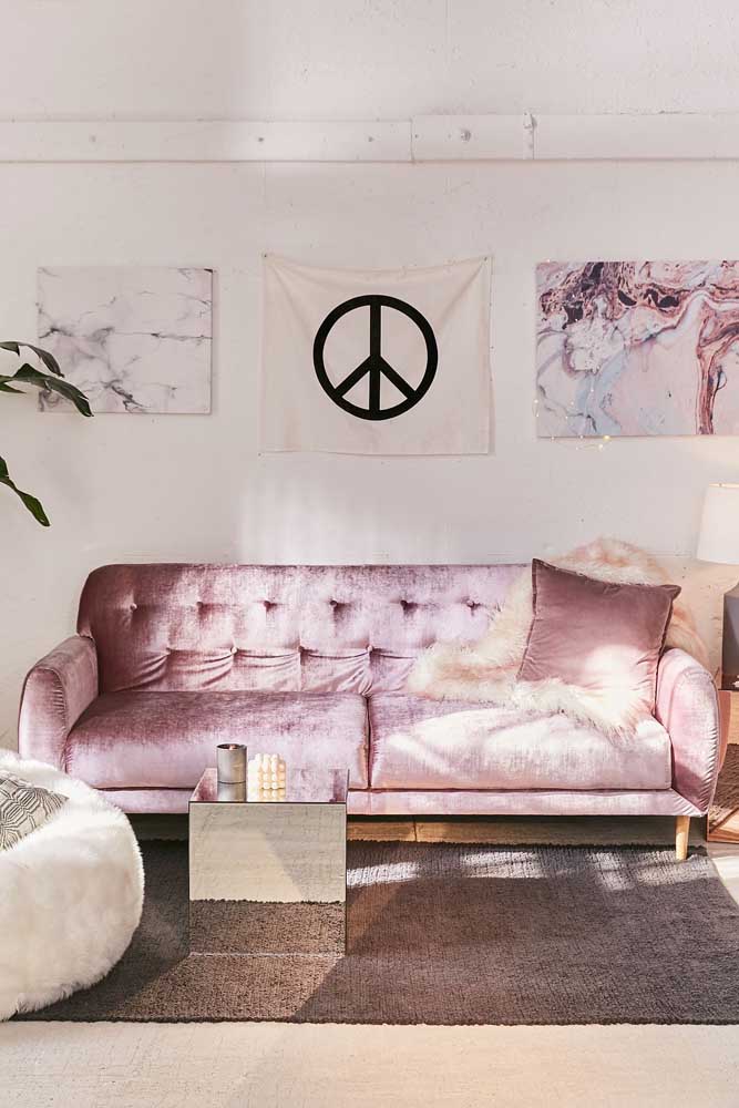 A sala de estar toda hipster apostou em um sofá de veludo cor de rosa com encosto em capitonê