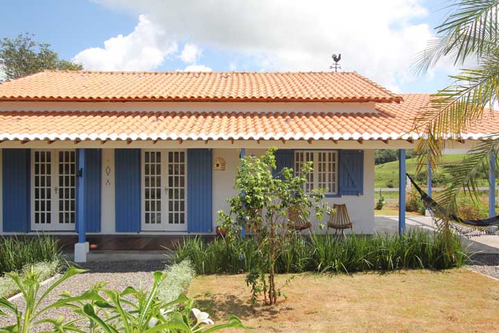 Casa rústica com telhado colonial ornando com os acabamentos das portas e janelas