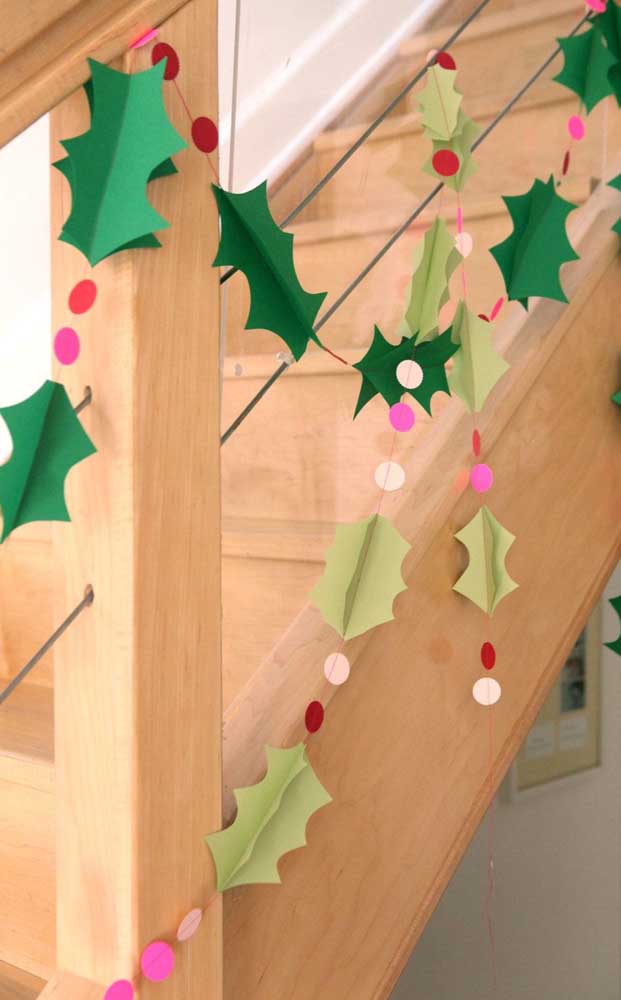 Cordão natalino feito com árvores de papel para adornar o que quiser, aqui, a dica é usar junto à escada